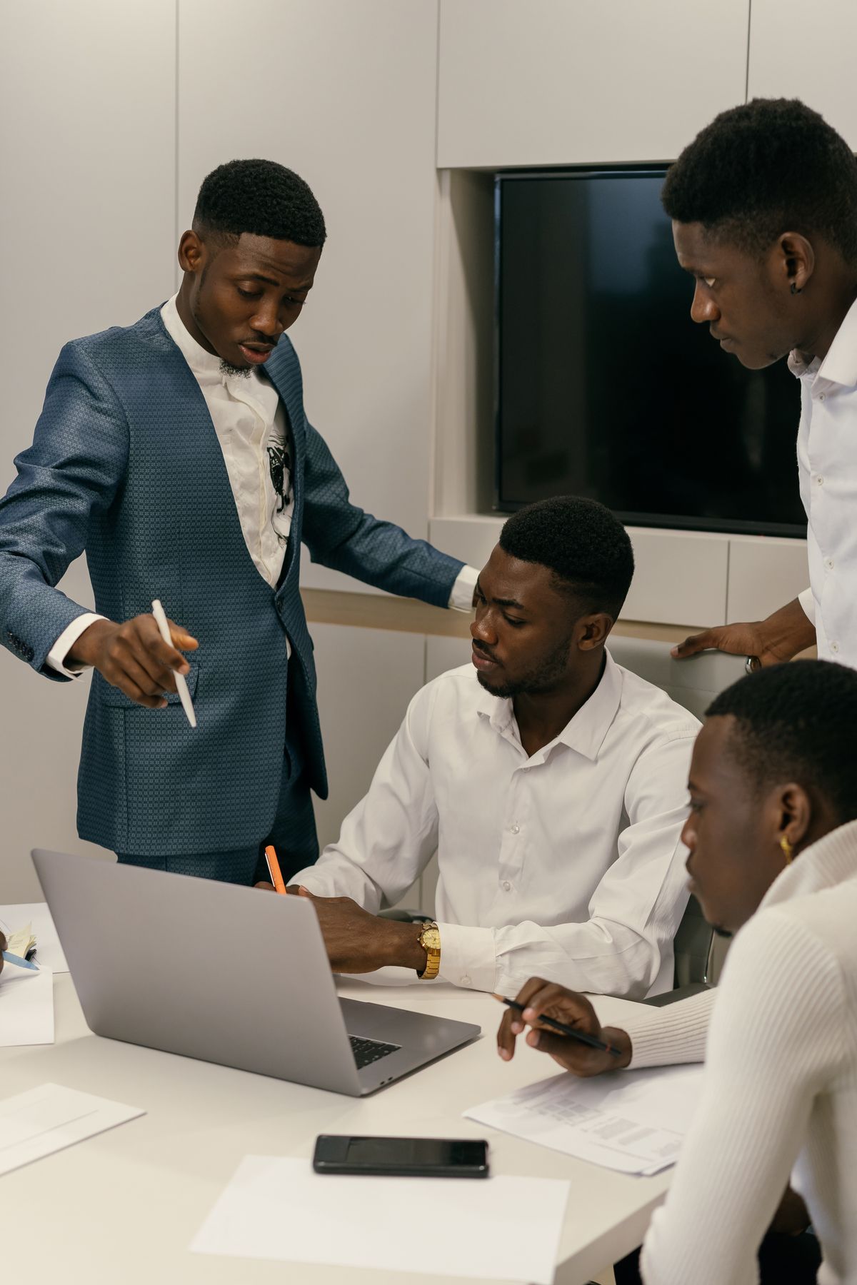 A team reviewing work together around a laptop in an office